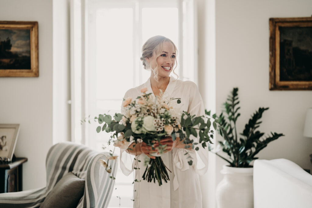 a beautiful blonde bride holding a bunch of flowers on her wedding day in Southern Italy after her bridal hair and makeup trial.