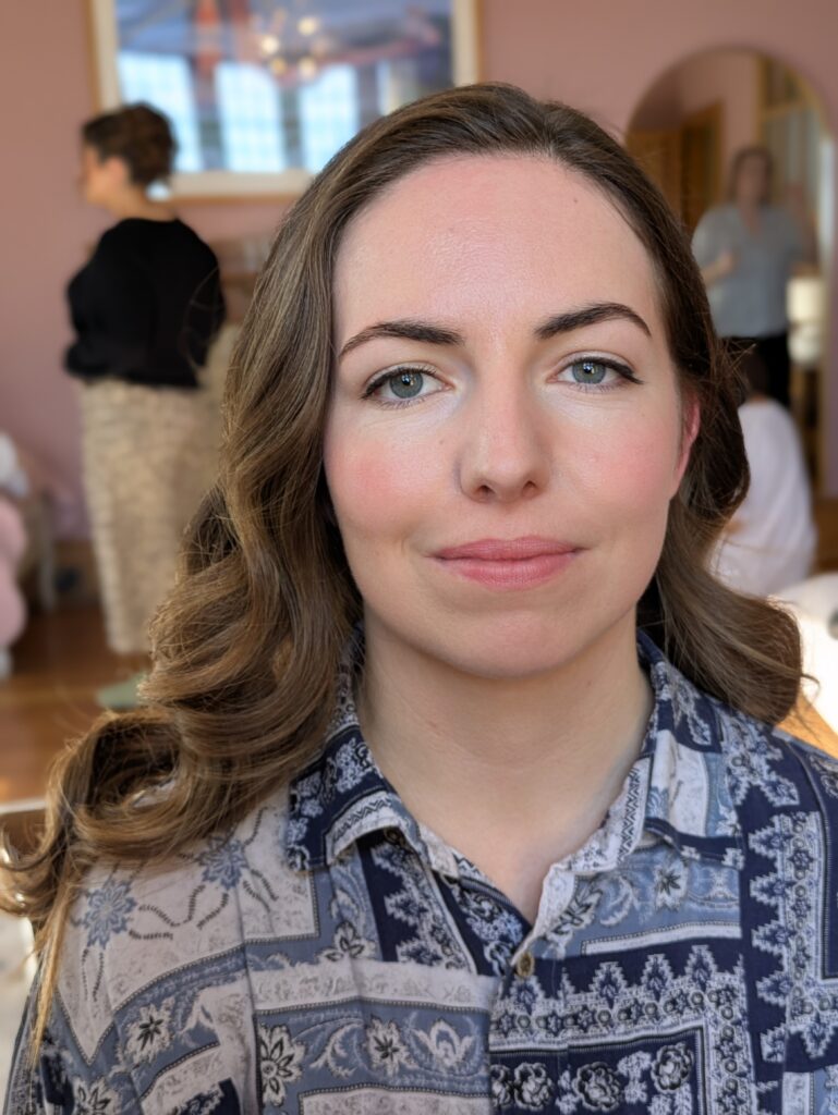 a bride on her wedding day at coombe lodge. she is looking into the camera and her hair is in a hollywood wave and a subtle eyeliner flick